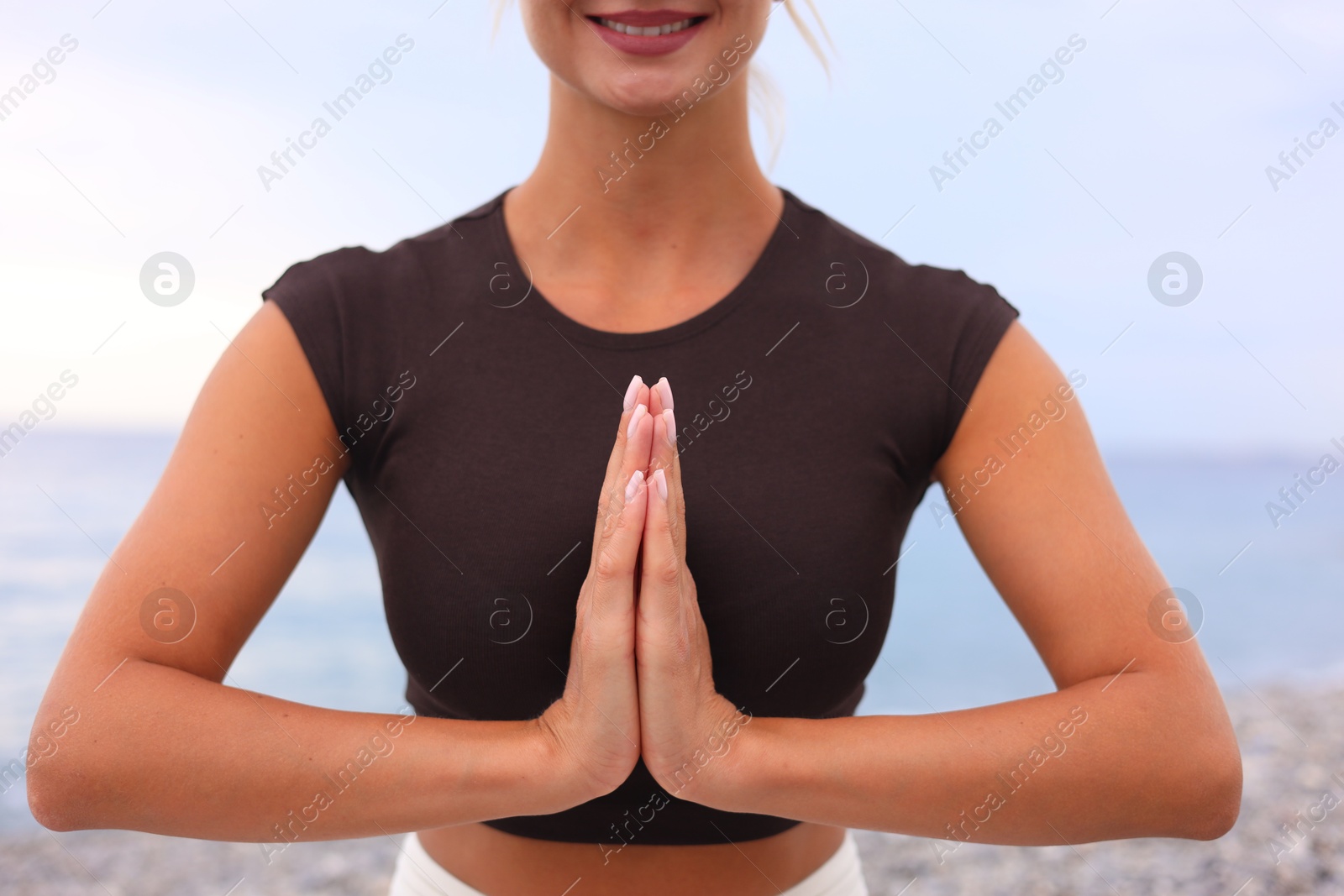 Photo of Young woman practicing yoga at beach, closeup
