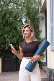 Photo of Beautiful young woman with yoga mat outdoors