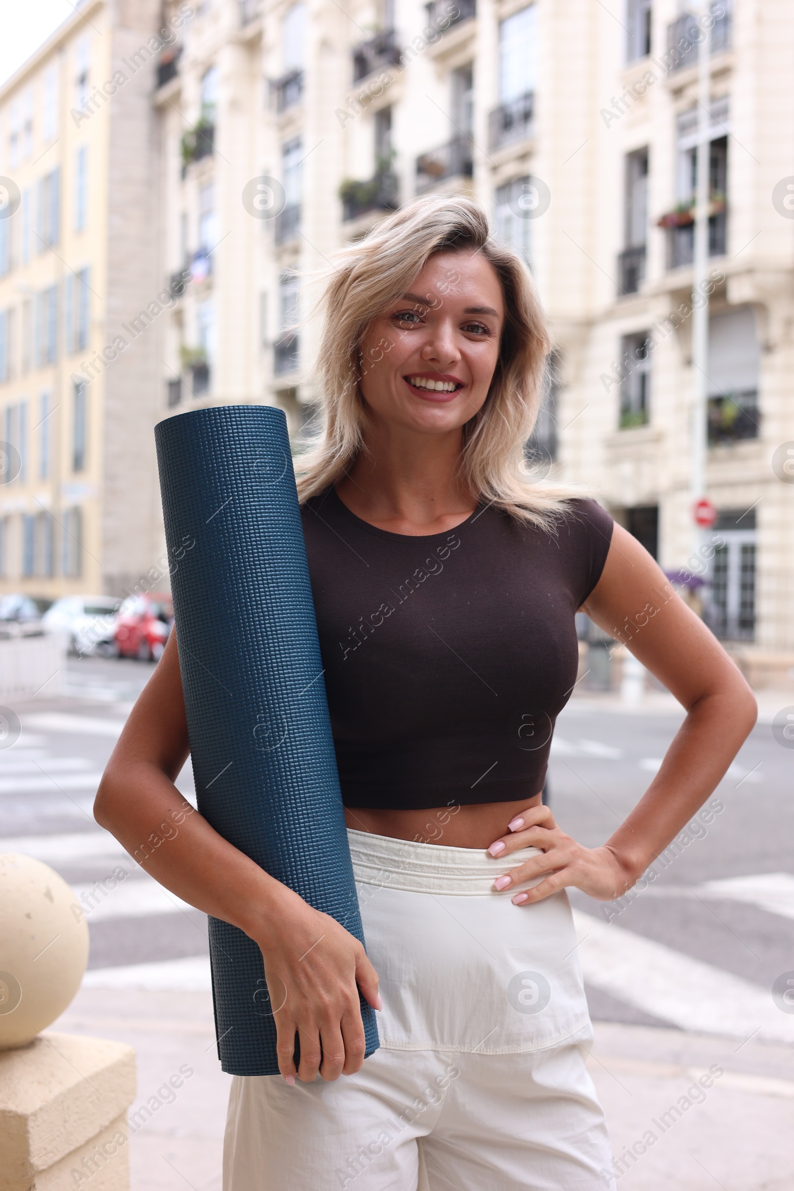 Photo of Beautiful young woman with yoga mat outdoors
