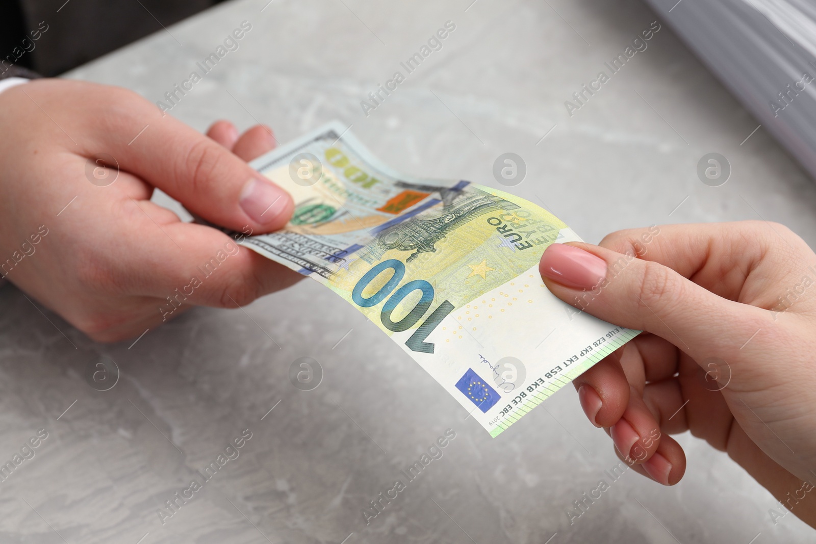 Image of Money exchange. Man and woman holding banknote at table, closeup. Bill changing from dollar to euro