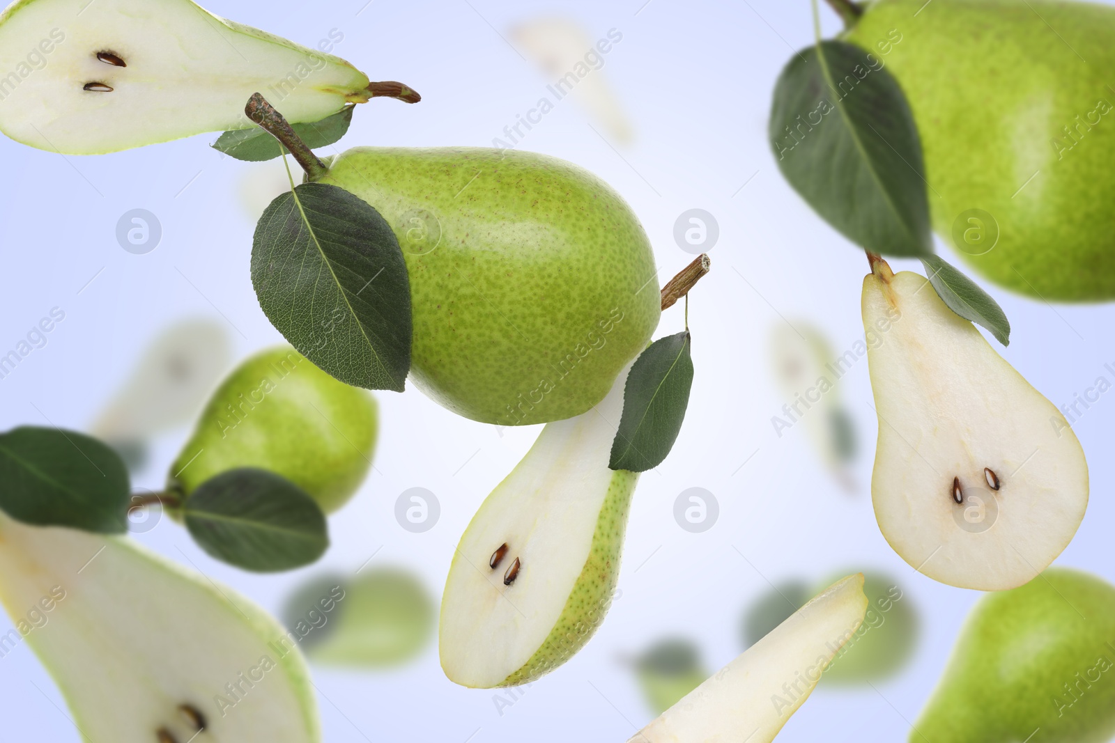 Image of Fresh green pears flying in air on light blue background