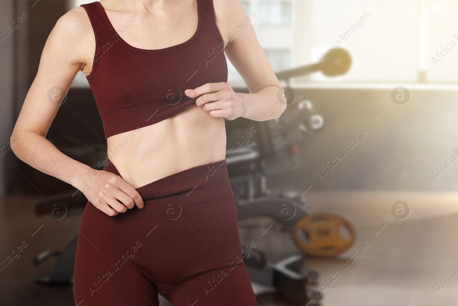Image of Athletic woman with flat belly in gym, closeup