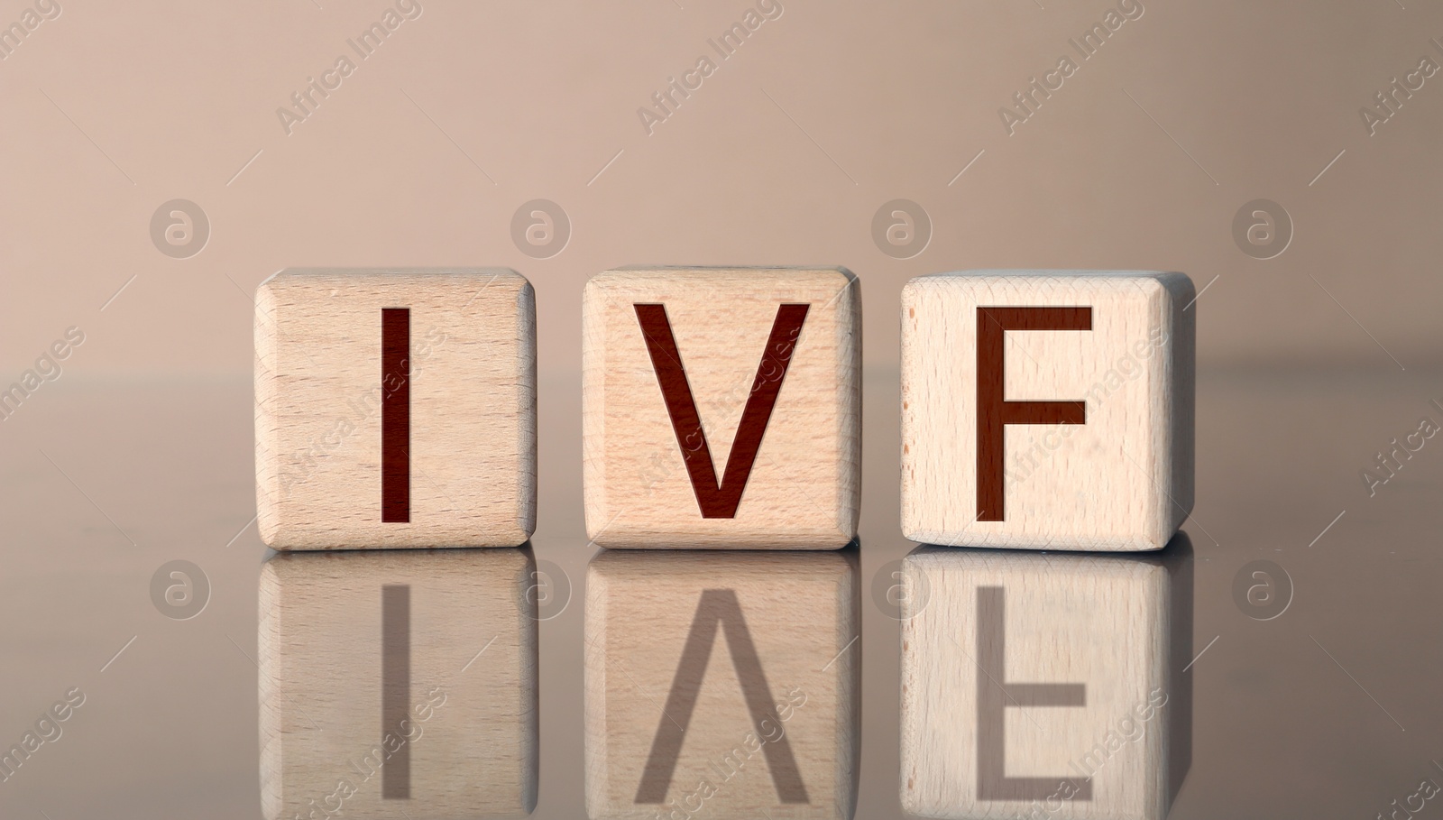 Image of In vitro fertilization. Wooden cubes with abbreviation IVF on pale brown background. Banner design