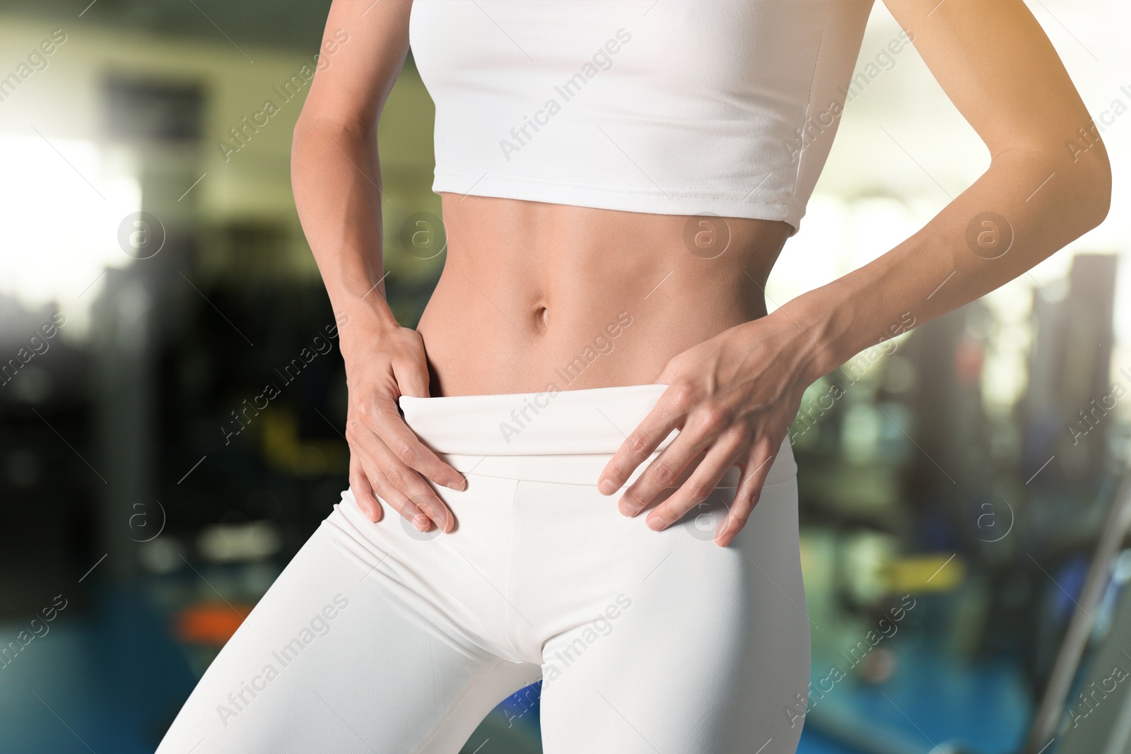 Image of Athletic woman with flat belly in gym, closeup