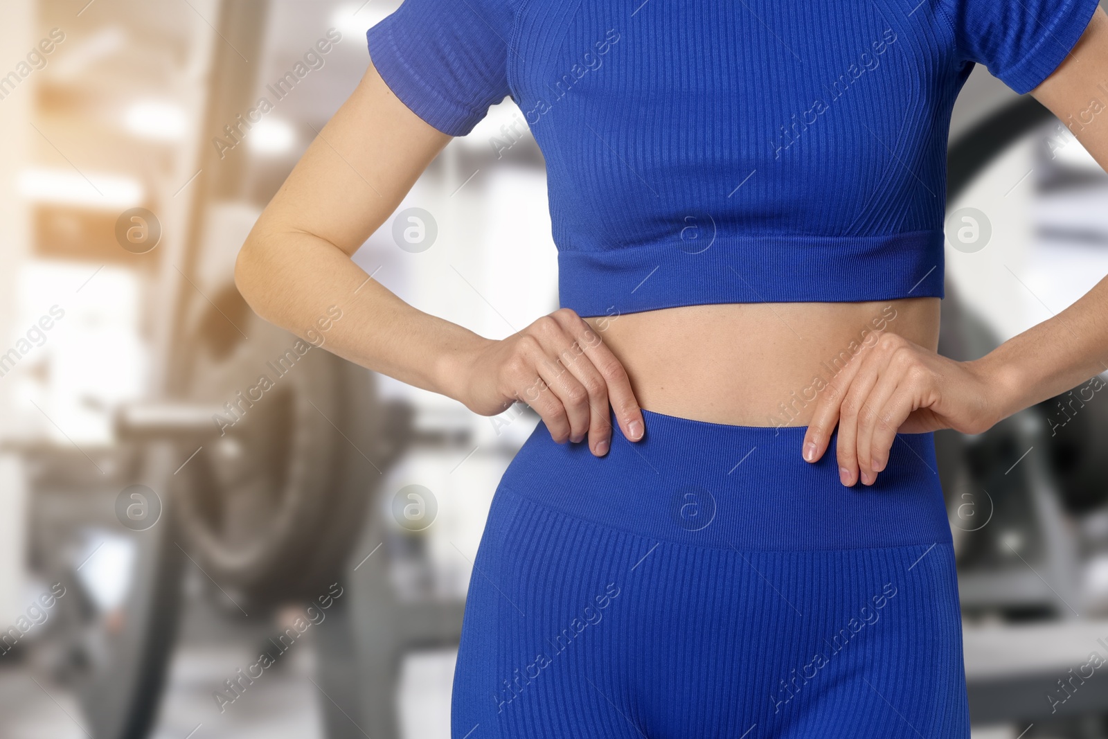 Image of Athletic woman with flat belly in gym, closeup