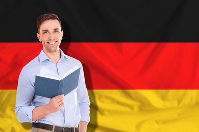 Image of Student or teacher with book against flag of Germany. Language school
