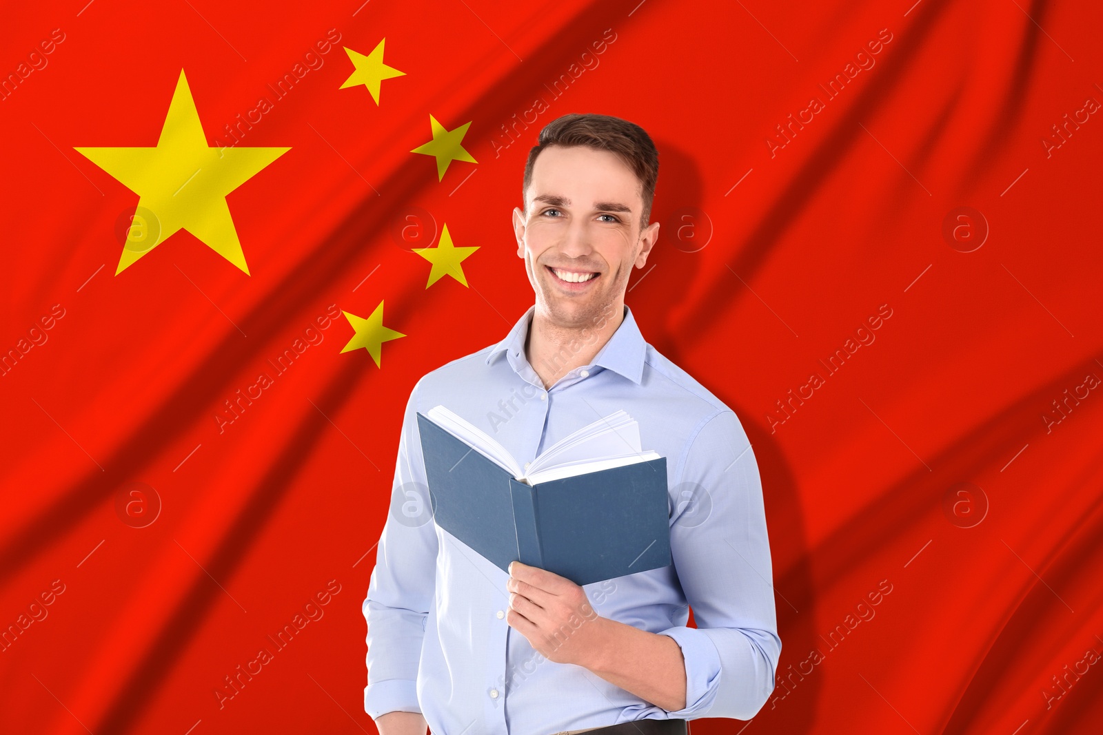 Image of Student or teacher with book against flag of China. Language school