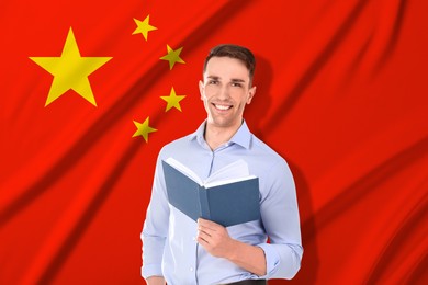 Image of Student or teacher with book against flag of China. Language school