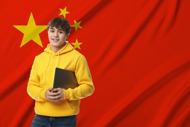 Image of Student with laptop against flag of China. Language school