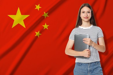 Image of Student with laptop against flag of China. Language school