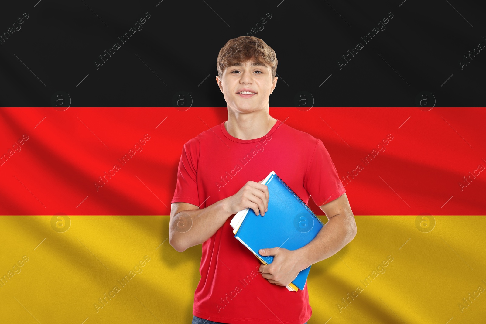 Image of Student with notebooks against flag of Germany. Language school