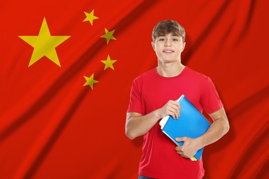 Image of Student with notebooks against flag of China. Language school