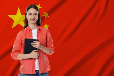 Image of Student with notebook against flag of China. Language school