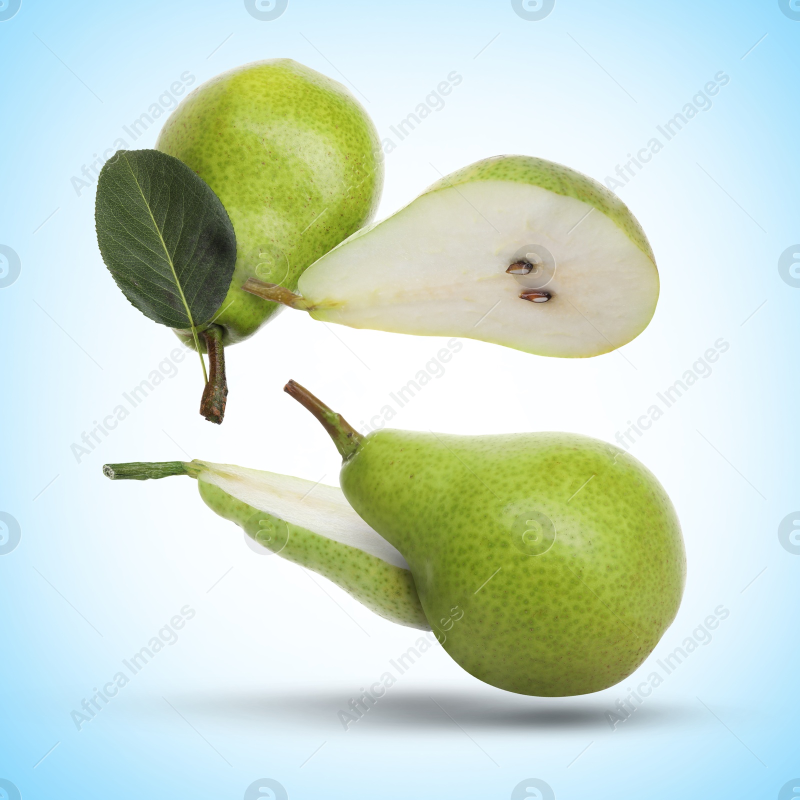 Image of Fresh green pears flying in air on light blue background