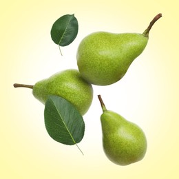Image of Fresh green pears flying in air on light yellow background