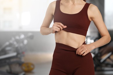 Image of Athletic woman with flat belly in gym, closeup