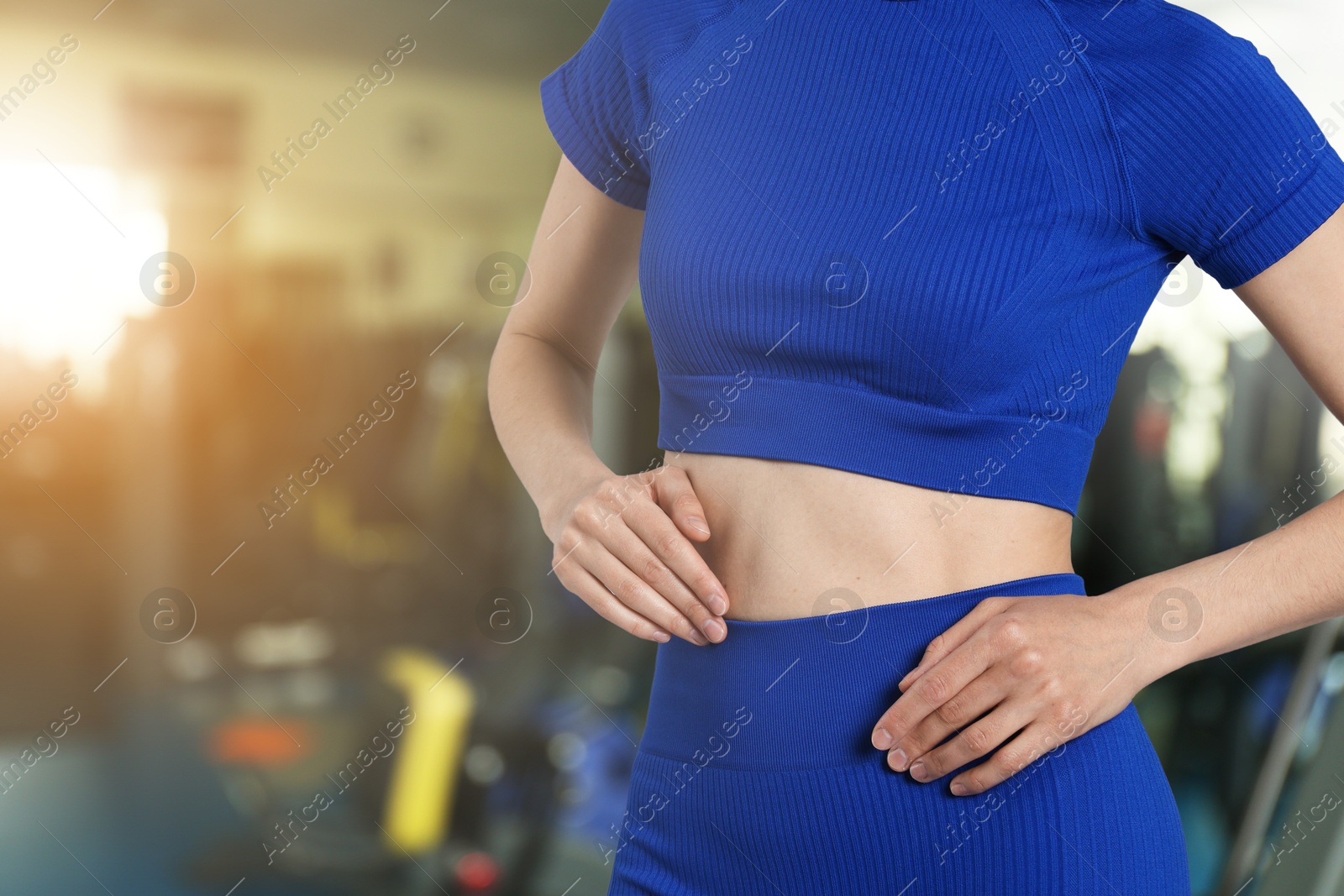 Athletic woman with flat belly in gym, closeup Image of Athletic woman with flat belly in gym, closeup