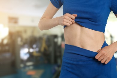 Image of Athletic woman with flat belly in gym, closeup