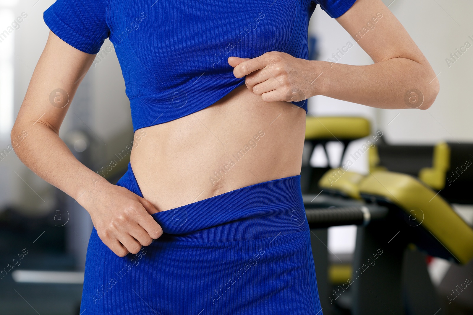 Image of Athletic woman with flat belly in gym, closeup