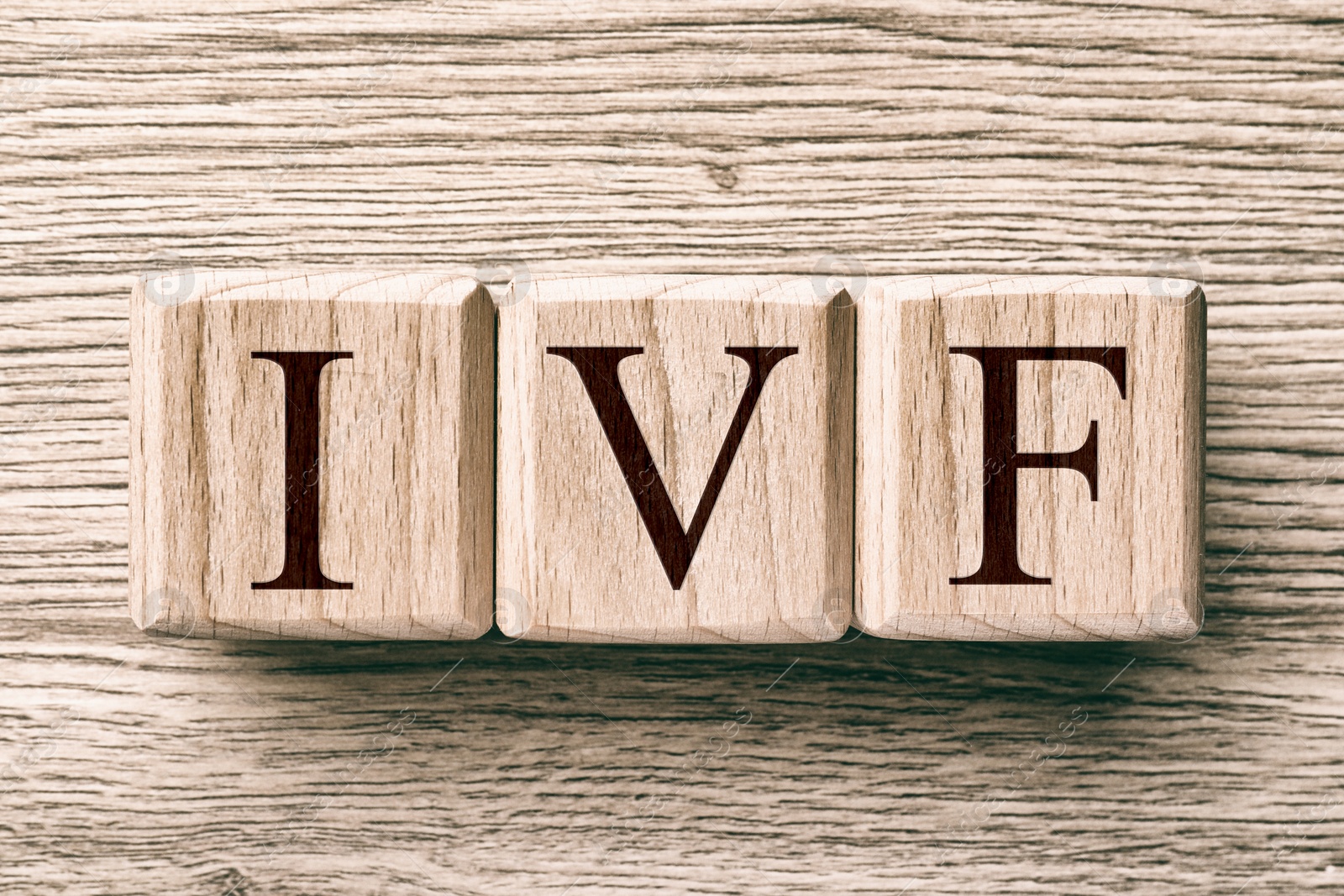 Image of In vitro fertilization. Cubes with abbreviation IVF on wooden background, top view