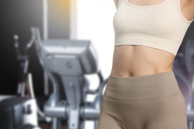 Image of Athletic woman with flat belly in gym, closeup