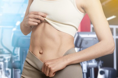 Image of Athletic woman with flat belly in gym, closeup