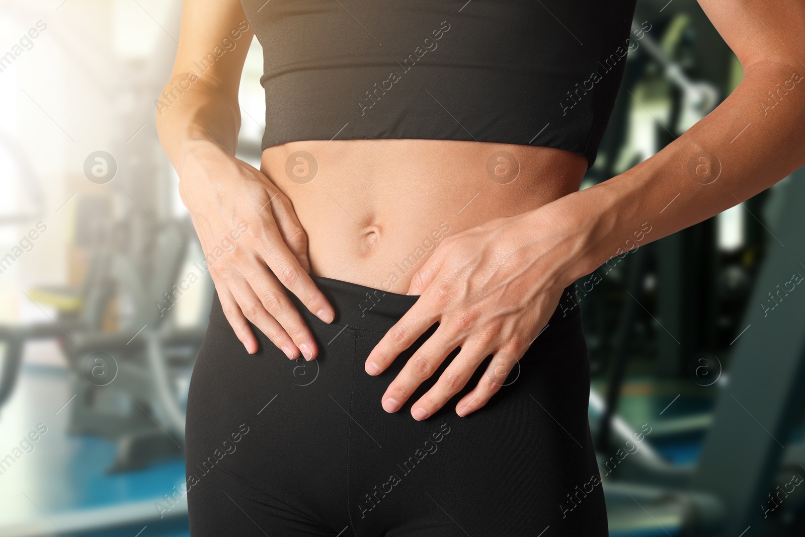 Athletic woman with flat belly in gym, closeup Image of Athletic woman with flat belly in gym, closeup