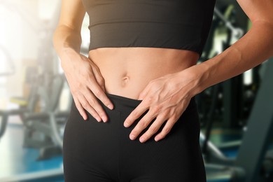 Image of Athletic woman with flat belly in gym, closeup