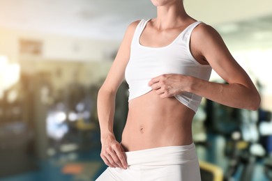 Image of Athletic woman with flat belly in gym, closeup