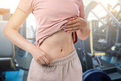 Image of Athletic woman with flat belly in gym, closeup