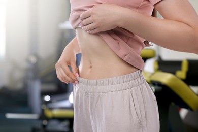 Image of Athletic woman with flat belly in gym, closeup