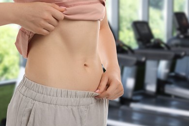 Image of Athletic woman with flat belly in gym, closeup
