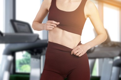 Image of Athletic woman with flat belly in gym, closeup