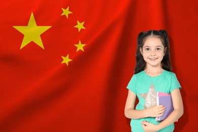 Image of Little girl with notebooks against flag of China. Language school