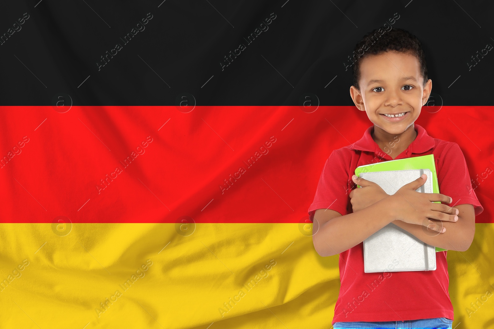 Image of Little boy with notebooks against flag of Germany. Language school