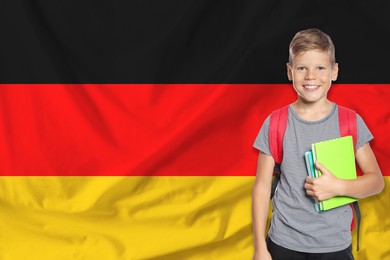 Image of Little boy with backpack against flag of Germany. Language school