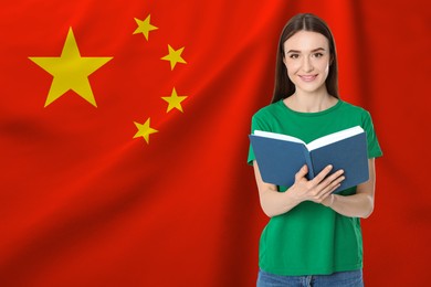 Image of Student or teacher with book against flag of China. Language school