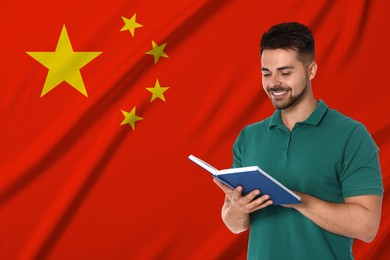 Image of Student or teacher with book against flag of China. Language school