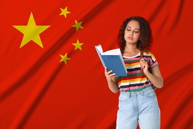Image of Student with book against flag of China. Language school