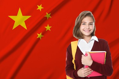 Image of Student with backpack and notebooks against flag of China. Language school