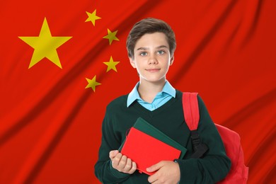 Image of Student with backpack and notebooks against flag of China. Language school