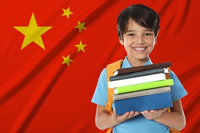 Image of Little boy with books against flag of China. Language school