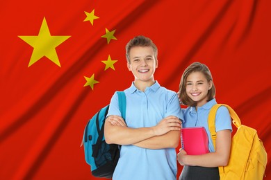 Image of Students with backpacks against flag of China. Language school