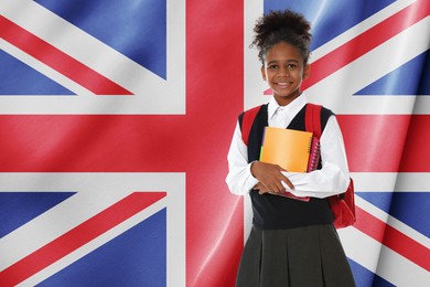 Image of Little girl with backpack and notebooks against flag of United Kingdom. Language school