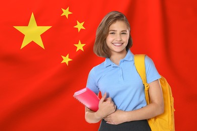 Image of Happy student with backpack and notebook against flag of China. Language school