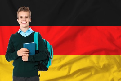 Image of Happy student with backpack and book against flag of Germany. Language school