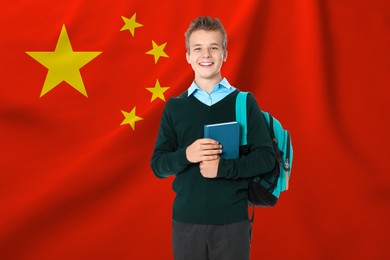 Image of Happy student with backpack and book against flag of China. Language school