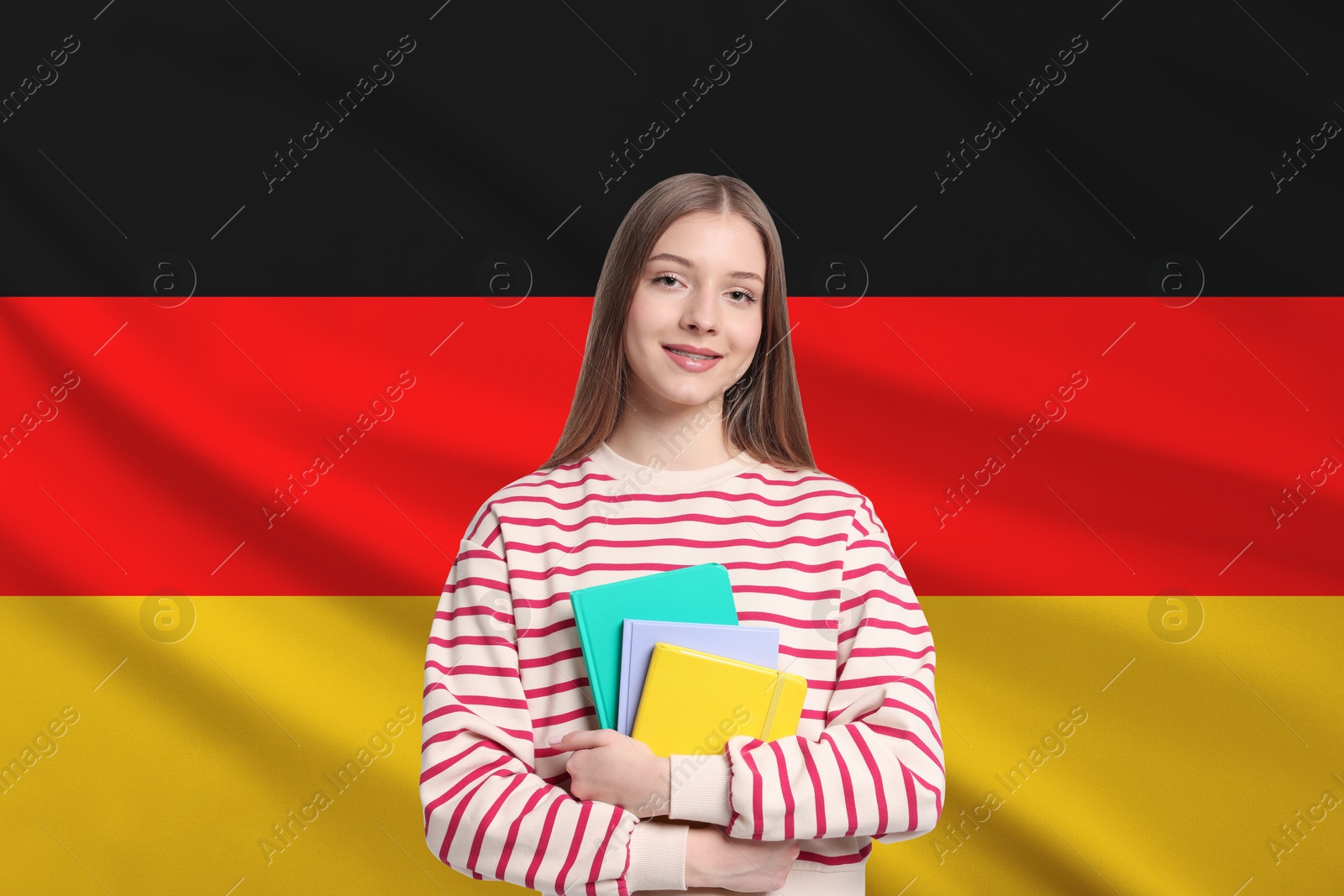 Image of Student with notebooks against flag of Germany. Language school