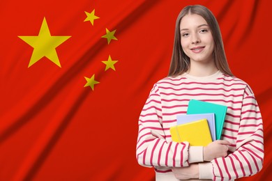 Image of Student with notebooks against flag of China. Language school