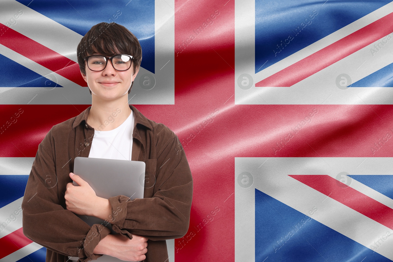 Image of Student with eyeglasses and laptop against flag of United Kingdom. Language school